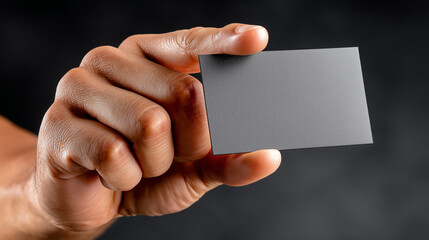 Fototapeta premium Mockup of a Matte-Finish Business Card Held Between Thumb and Forefinger as if Being Presented