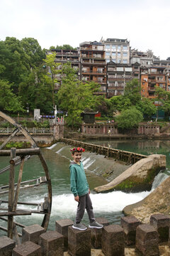 Tourist child and Fenghuang Ancient Town, Hunan, China. Chinese landmark, monument, sight. Beautiful view. Bridge, Tuojiang river in Fenghuang. Old architecture, scenery, landscape