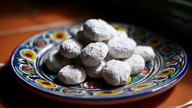 Close Up of Delicious Homemade Mexican Wedding Cookies on a Traditional Colorful Ceramic Plate.