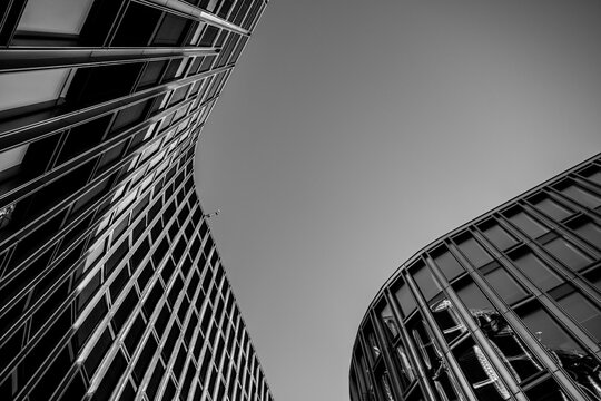 Dramatic monochrome architecture skyscraper with modern curves and abstract lines from low perspective shaping a bold skyline in moody light