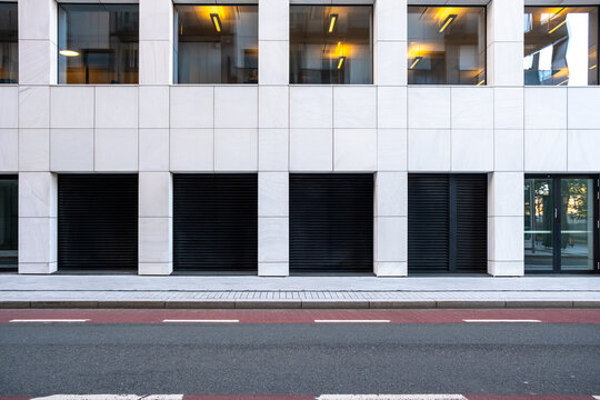 Modern urban street with minimal architecture building facade and windows beside empty road highlighting clean geometry and simple contemporary space