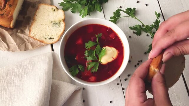 Delicious bowl of borscht served with fresh bread and herbs