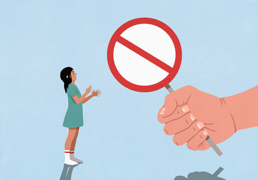 Large fist holding Do Not Enter sign in front of surprised girl gesturing on blue background