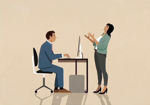 Businesswoman complaining to businessman working at computer in office