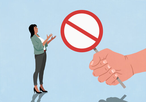 Woman gesturing in frustration at large fist holding refusal sign
