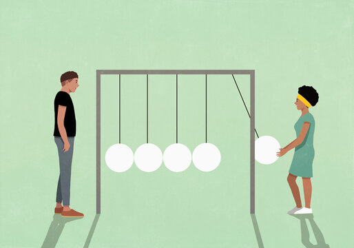 Man and woman on opposite ends of Newton's cradle against green background