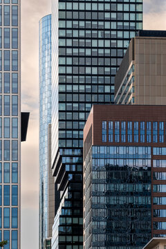 Glass steel skyscraper tower shapes Frankfurt Germany corporate skyline as modern architecture rises with crisp reflection between highrises