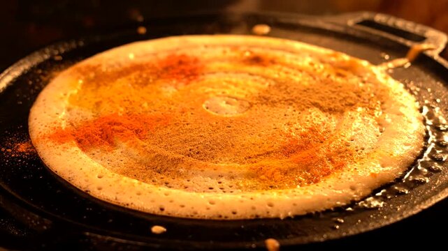 Delicious Dosa Cooking on a Hot Griddle with Spices.
