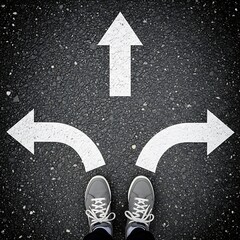 Fototapeta premium Urban pavement photography featuring gray sneakers and white painted arrows illustrating the concept of making a difficult choice.