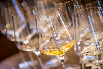 a glass of white wine under empty glasses