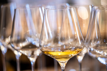 a glass of white wine under empty glasses