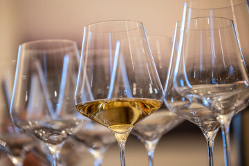 a glass of white wine under empty glasses