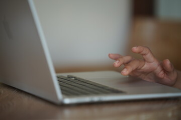 Close-up of hands typing on a laptop keyboard, remote work or digital nomad lifestyle.