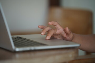Close-up of hands typing on a laptop keyboard, remote work or digital nomad lifestyle.