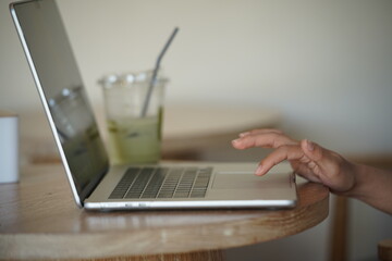 Close-up of hands typing on a laptop keyboard, remote work or digital nomad lifestyle.