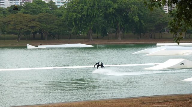 Man Cable Skiing and Wakeboarding at a Tropical Outdoor Water Park