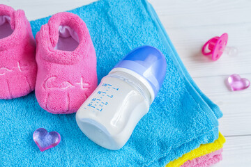 baby bottle with milk and towel on wooden background