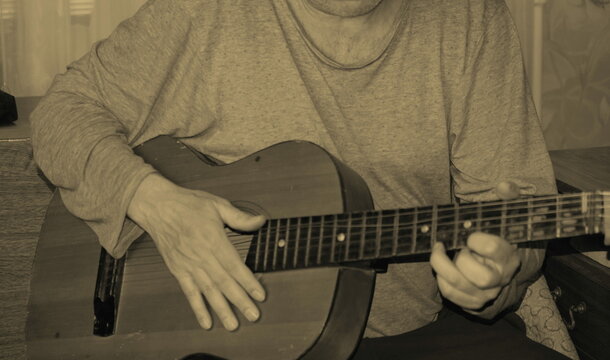 Middle-aged man playing old guitar visible human hands instrument house apartment dacha sitting