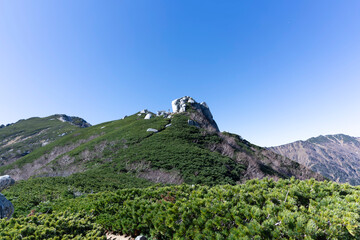 中央アルプス・空木岳の登山道から見上げる巨岩「駒石」と青空