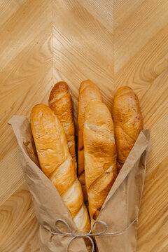 Close-up photo of kraft paper bag with fresh Italian baguettes. French bread bakery