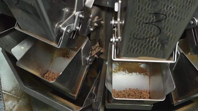 Multihead weigher machine precisely portions dry granular pet food on an automated industrial packaging line