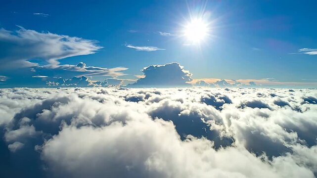 Aerial view shows the sun shining brightly above a sea of f white clouds, creating a serene and ethereal atmosphere.