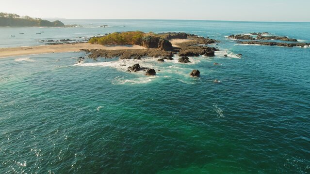 Small rocky peninsula surrounded by turquoise ocean and San Juanillo beach.