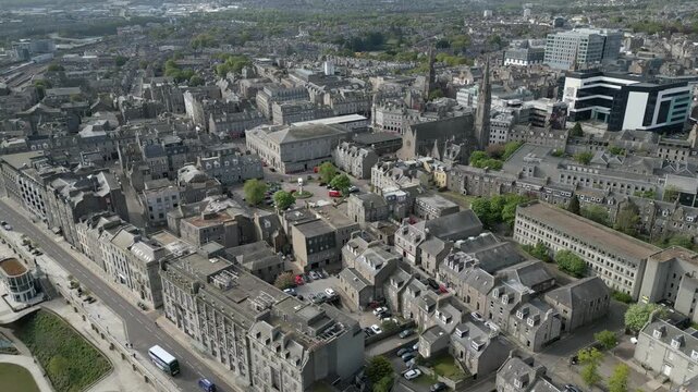 Wide aerial drone shot orbiting the historic St Mary of the Assumption Cathedral and surrounding granite architecture in Aberdeen city centre, Scotland.