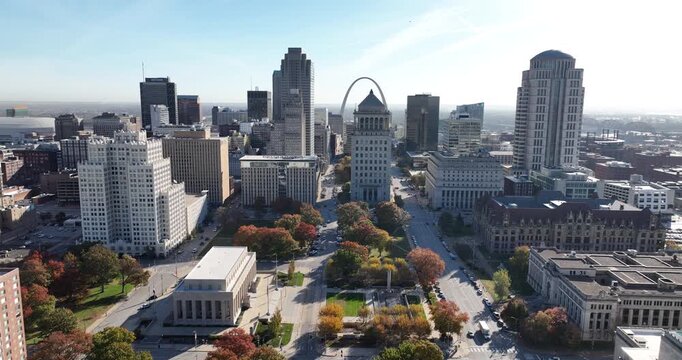 Cinematic drone footage of downtown Saint Louis skyline at sunrise with glowing city buildings and calm morning atmosphere