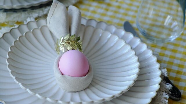 Easter table setting. Plate with decorated Easter egg. Festive dinner. 