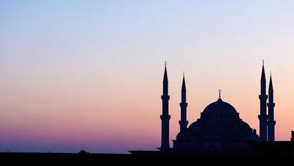 Fototapeta premium Majestic Islamic mosque architecture silhouetted against a breathtaking twilight sky, capturing the serene spiritual essence of a tranquil evening