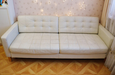 Simple white sofa in a room with bright lights during the day