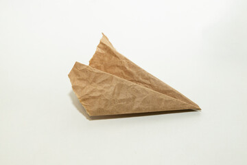 The homemade plane made from old vintage torn brown paper on white background