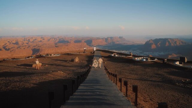 Tourists in Saudi Arabia travel in AlUla, running with the view on canyon of Al Ula. Landscapes of Arabic peninsula.