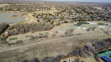 Obraz premium Homes near Lantana golf corridor overlook fairways, ponds, tennis courts integrated into community. Green turf, sand textures, winter trees, varied roof patterns layered suburban, Lantana, TX