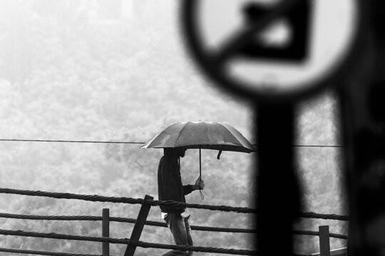 Pessoas andando na chuva com guarda-chuva. 