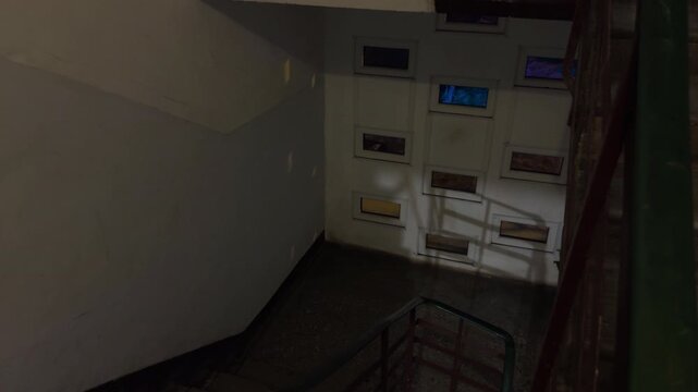 Overhead view of lit staircase with shadowing effects highlighting urban surveillance activity at night