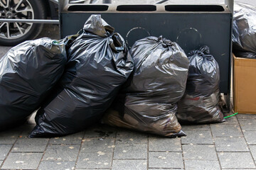 Pile of plastic garbage bags outside on urban street