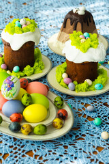 Easter traditional food for Russia: colorful painted Easter eggs, Eastre cakes, tradition Russian cottage cheese dish called Easter with chocolate on laid table with blue lace tablecloth