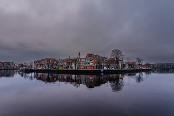 Obraz premium Cloudy day in Haarlem with beautiful reflection in the Spaarne river