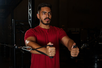 Man Performing Standing Cable Chest Fly Exercise in Gym