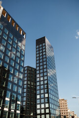 Obraz premium Modern office buildings with glass facades against clear blue sky in Milan. Minimal urban architecture and corporate real estate concept.