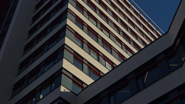 Modern Hospital: Sunlit and shaded balcony interplay creates drama. Corner of city building with contrasting light and shadow