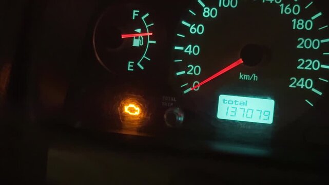 Dashboard displaying engine alert. Close view of dashboard indicating engine problem during night driving