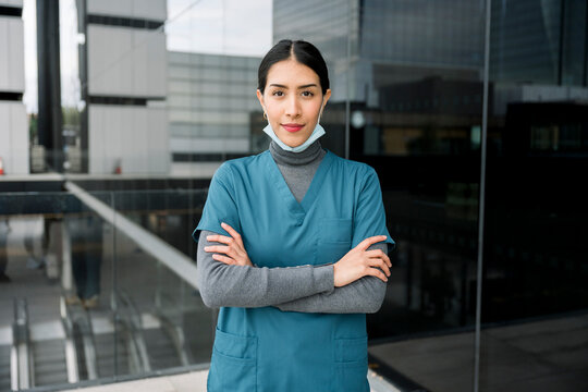 Healthcare professional standing confidently with mask pulled down