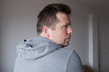 Fototapeta premium Offended man turning his back and looking back over his shoulder with resentment