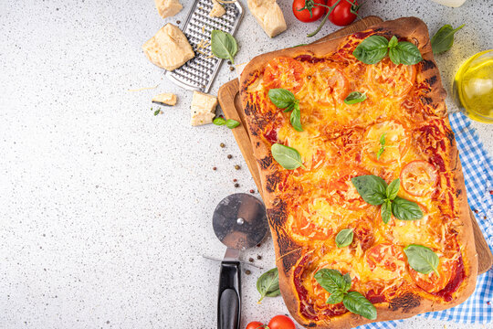 Rectangular homemade pizza with tomatoes and basil