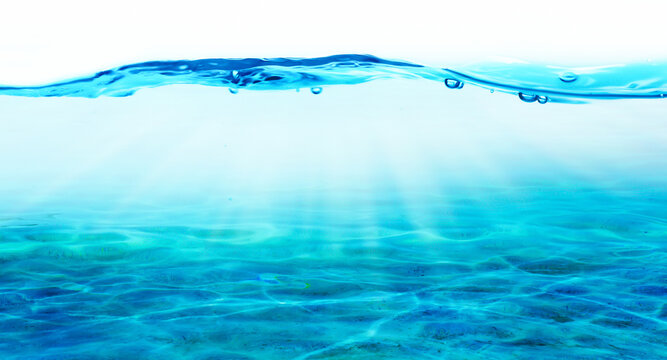 abstract water line over ocean floor with sunlight reflections, underwater side view close-up with copy space for travel, vacation and beach holidays, beautiful transparent water background