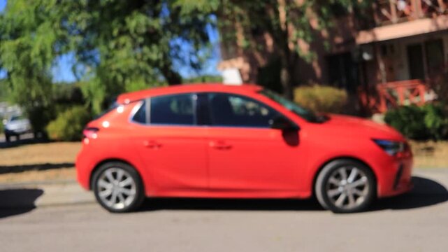 A company manager delivers a red car and hands over the keys to a client, representing car rental service, vehicle delivery, leasing, financing, car sale and ownership transfer.