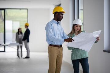 Construction team reviewing blueprints on building site